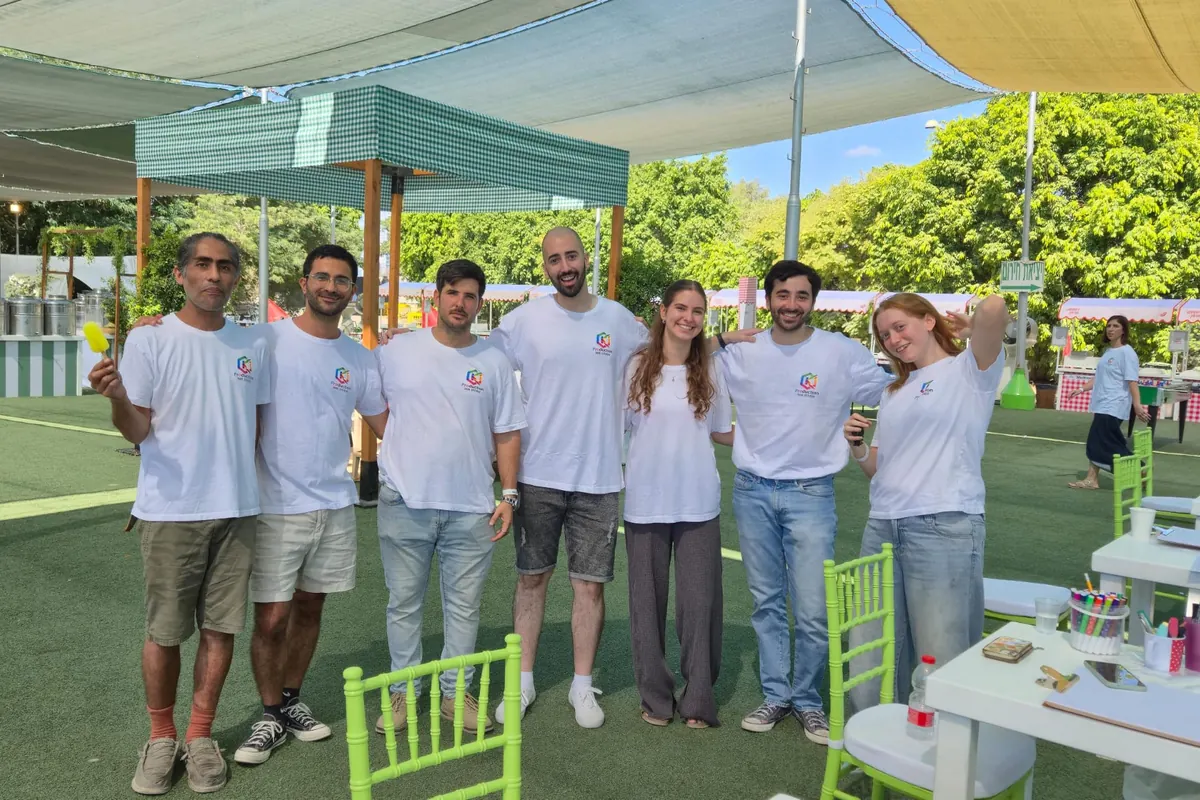 אמני מצוירים עומדים יחד ליד עמדות ציור באירוע