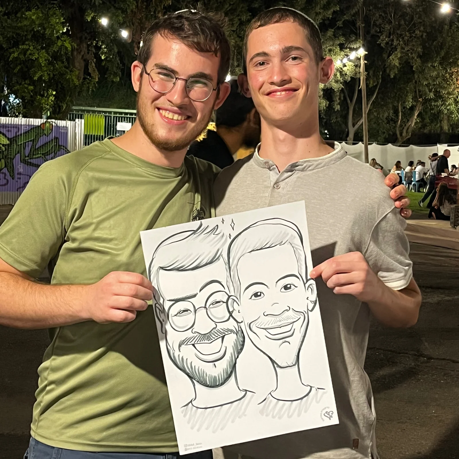 שני אורחים מחייכים ומציגים את הקריקטורה שלהם, מתוך עבודותיו של הלל בוחניק